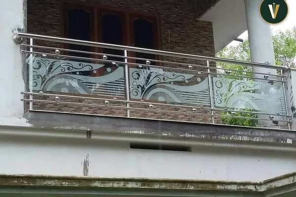 A balcony railing with a glass design.