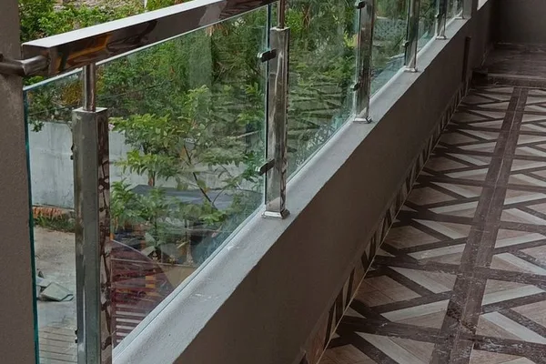 A glass balcony with metal railing.
