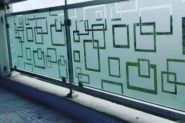 A balcony with a glass railing and a patterned design.
