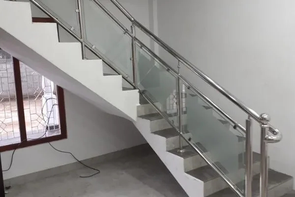 The staircase is made of glass and metal, and it has a modern design.