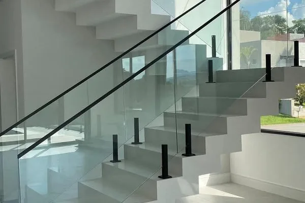 A glass staircase with black railings and white steps.