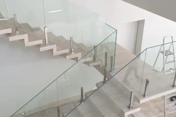 A glass staircase with a metal frame and silver metal railings.