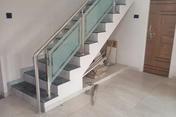 A staircase with a glass balustrade and a metal railing.