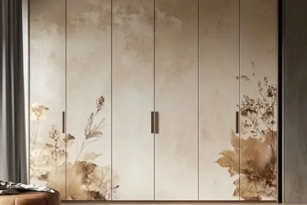 A white wardrobe with flower designs on the door.